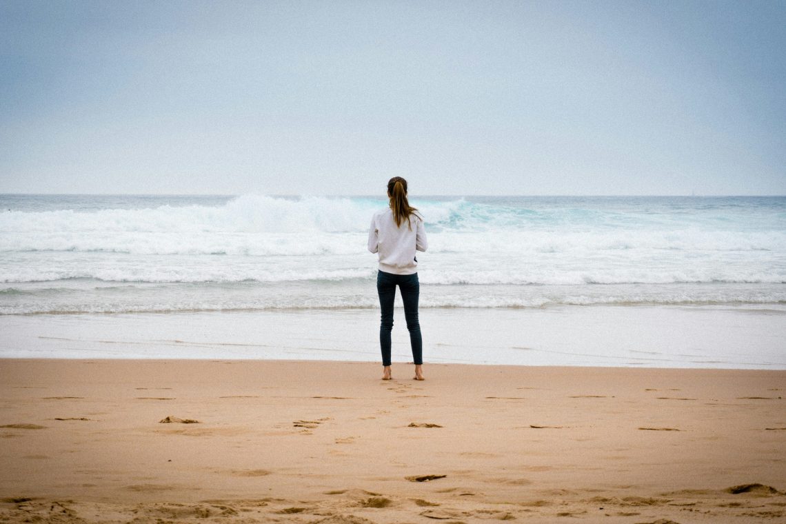 Was ist spirituelles Marketing und wie funktioniert es? Blog-Beitrag von Suzanne Frankenfeld (Bild-Beschreibung: Eine Frau steht am Strand und schaut aufs Meer.)