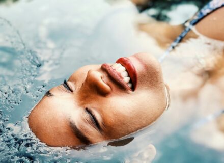 Hochsensibel energetischer Schutz – Beitragsbild zum Blogbeitrag "Brauchen Hochsensible energetischen Schutz?" von Suzanne Frankenfeld. Auf dem Bild zu sehen ist das Gesicht einer im Wasser liegenden Frau sehr nah fotografiert. Die Frau hat die Augen geschlossen und lächelt. Sie sieht freudvoll und entspannt aus.
